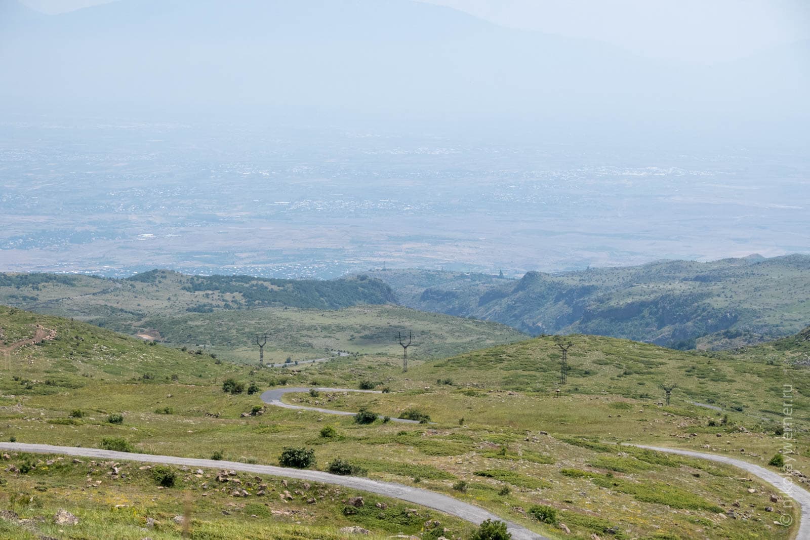 Вид скверху вниз на петляющую по склонам Арагаца дорогу. Даль тонет в дымке